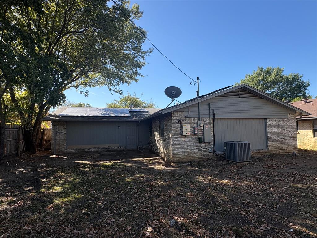 3717 Swallow Lane Irving, TX 75062 - Photo 2 of 11 Back of property with brick siding and roof mounted solar panels
