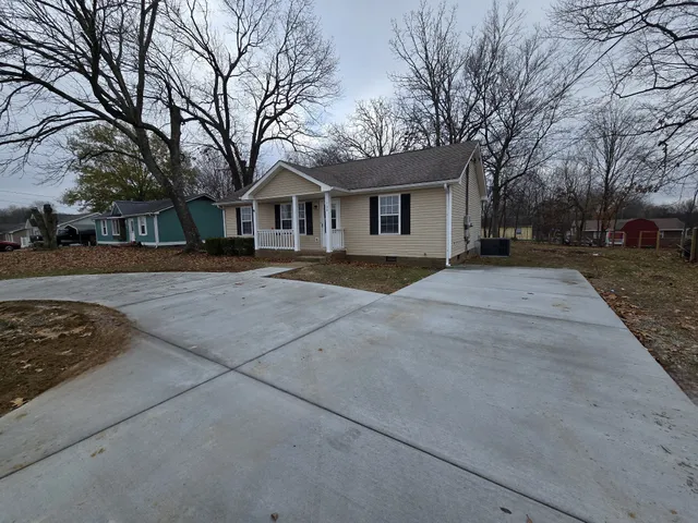 a front view of a house with a yard and trees
