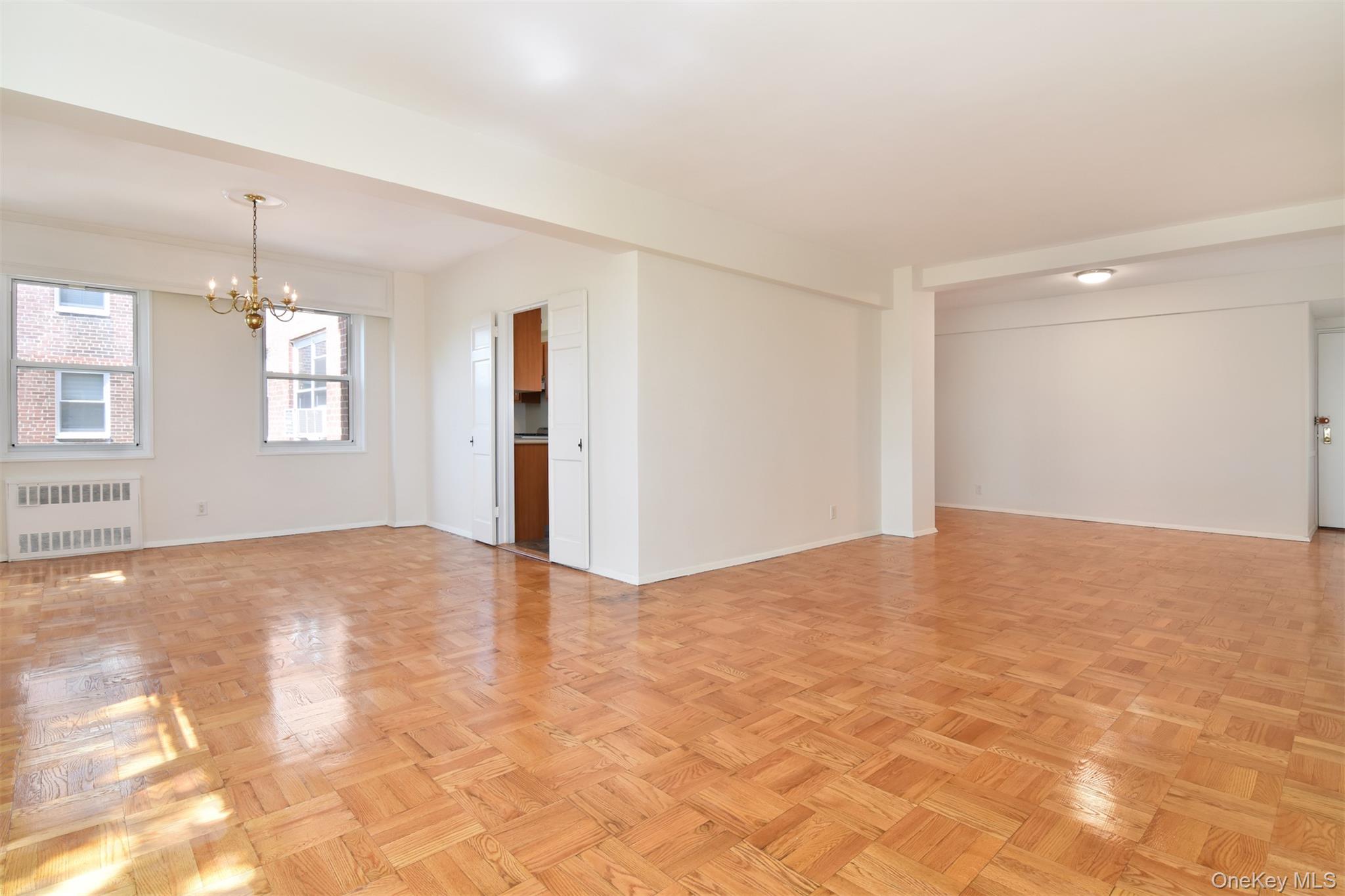 900 Palmer Road, Unit 7L Bronxville, NY 10708 - Photo 4 of 21 a view of an empty room with window and wooden floor
