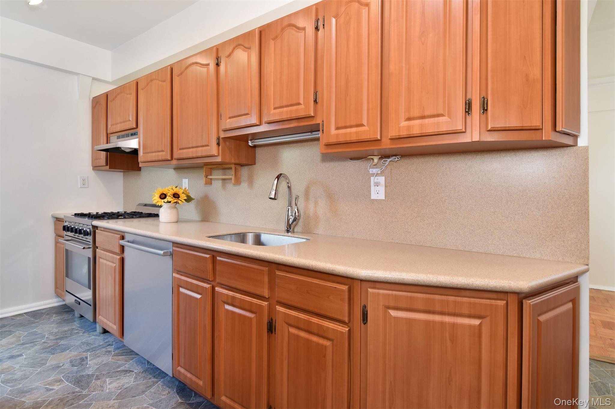 900 Palmer Road, Unit 7L Bronxville, NY 10708 - Photo 7 of 21 a kitchen with stainless steel appliances granite countertop a sink dishwasher and cabinets with wooden floor
