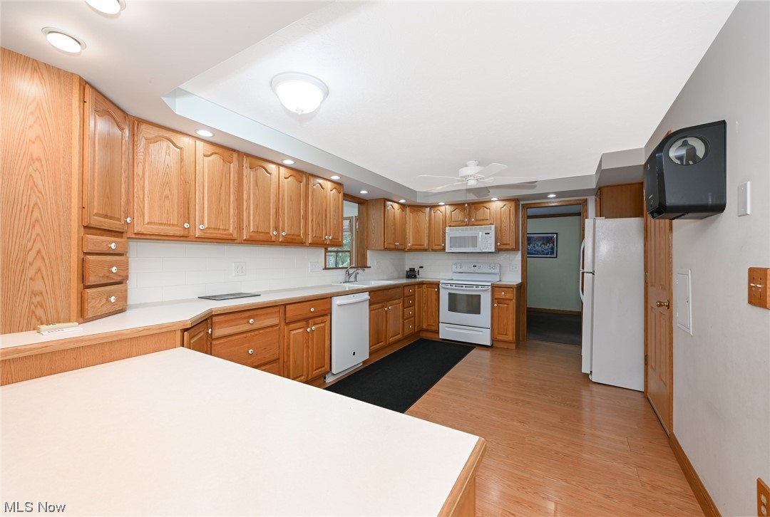 4574 Fishcreek Road Stow, OH 44224 - Photo 23 of 49 Kitchen featuring ceiling fan, tasteful backsplash, light wood-type flooring, white appliances, and sink