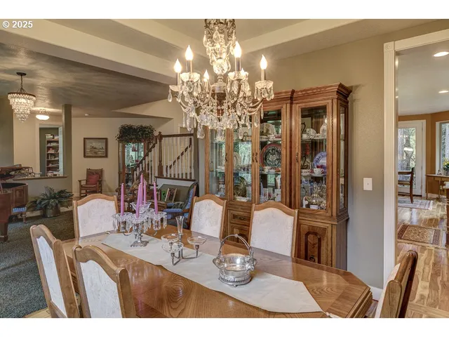 a dining room with furniture a chandelier and wooden floor