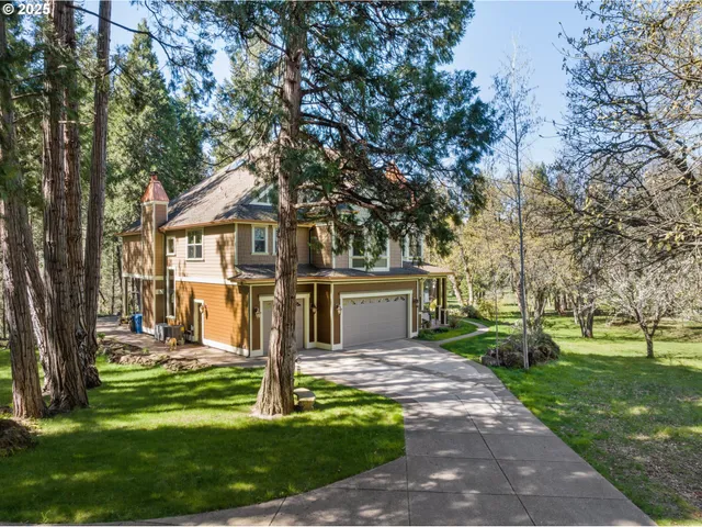 a front view of a house with a garden and trees