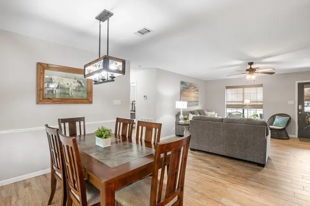 a view of a dining room with furniture a chandelier and wooden floor