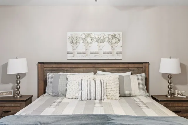 a view of a bedroom with wooden floor and a lamp