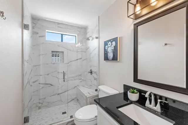 a bathroom with a sink toilet a mirror and shower