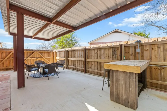 a view of a yard in front of a house with a large tree