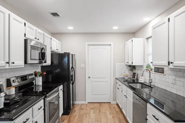 a kitchen with stainless steel appliances a refrigerator sink and stove