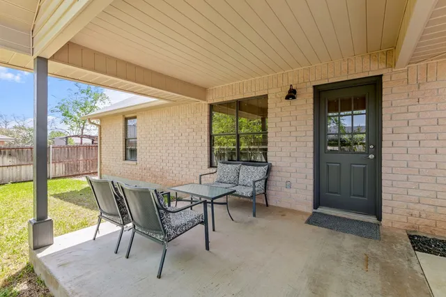 a view of a backyard with wooden fence and large trees