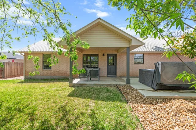 a backyard of a house with table and chairs