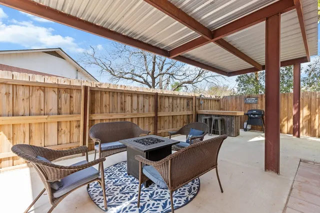 a view of a patio with a table chairs and a couple of flower plants