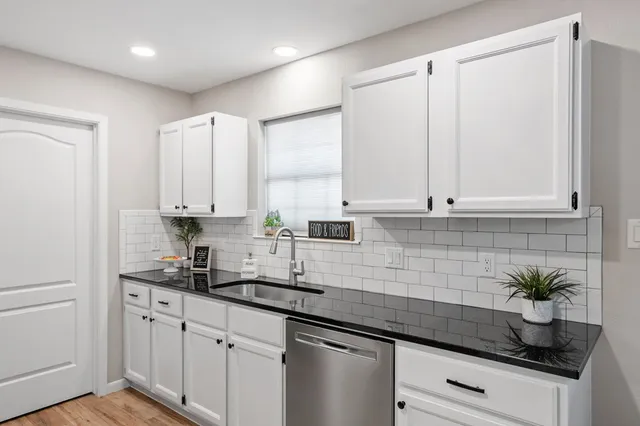 a kitchen with granite countertop white cabinets and white appliances