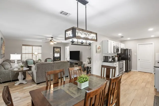 a view of a dining room with furniture a chandelier and wooden floor
