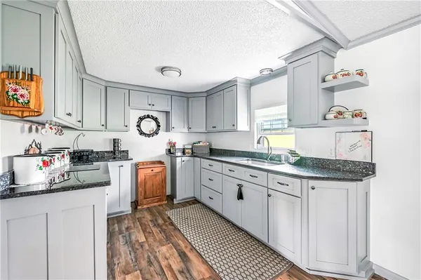 a kitchen with granite countertop a sink stove and cabinets