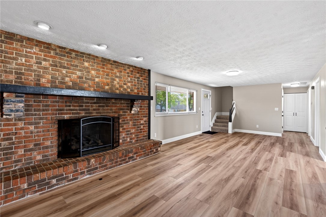5975 Rosalie Road Dayton, OH 45424 - Photo 6 of 48 This expansive living space features a warm brick fireplace and inviting wood flooring.