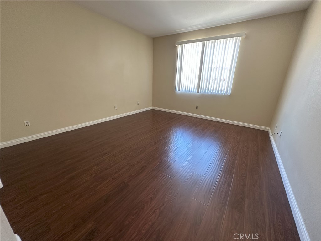 13352 Pleasant View Street Oak Hills, CA 92344 - Photo 11 of 13 an empty room with wooden floor and windows