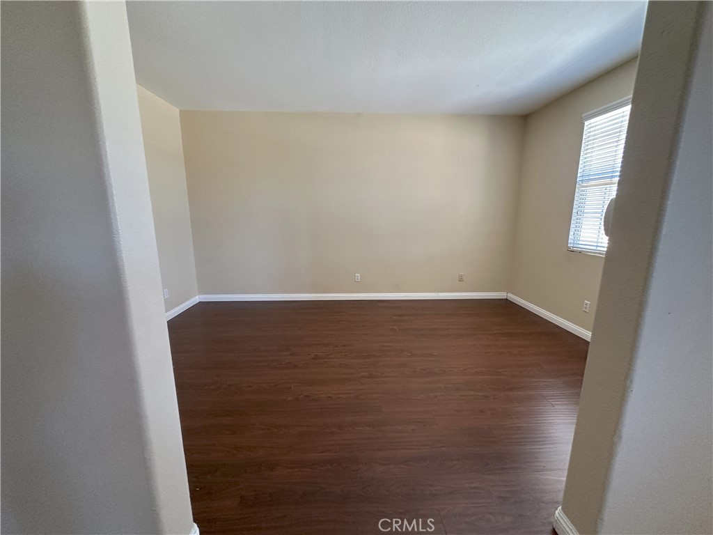 13352 Pleasant View Street Oak Hills, CA 92344 - Photo 13 of 13 a view of room with window and wooden floor