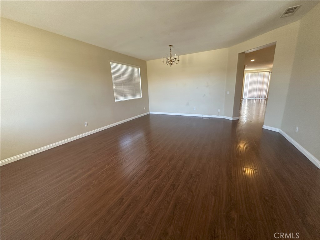 13352 Pleasant View Street Oak Hills, CA 92344 - Photo 2 of 13 a view of an empty room with wooden floor and a window