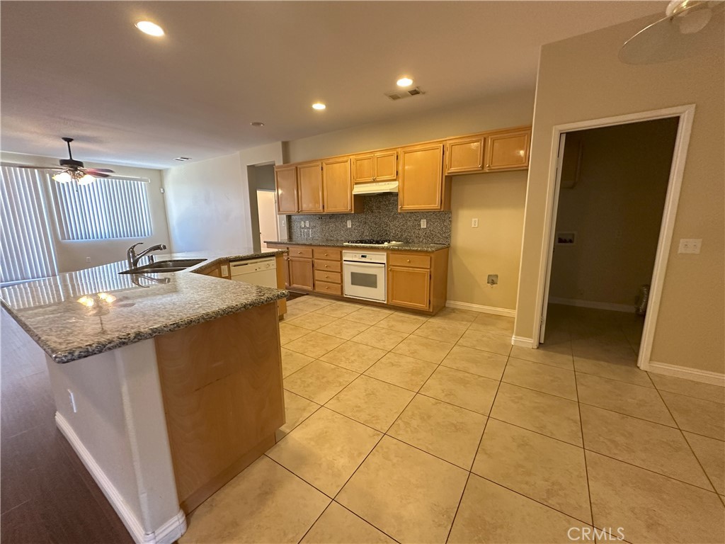 13352 Pleasant View Street Oak Hills, CA 92344 - Photo 8 of 13 a kitchen with stainless steel appliances granite countertop a sink and cabinets
