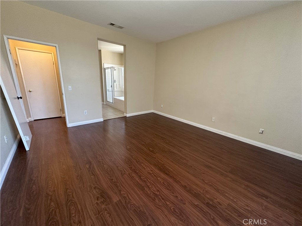 13352 Pleasant View Street Oak Hills, CA 92344 - Photo 10 of 13 a view of an empty room with wooden floor and a window