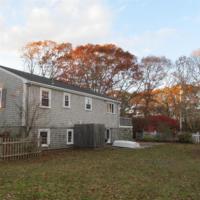 1 Mashnee Road Bourne, MA 02532 - Photo 23 of 29 a front view of a house with a yard and mountain view in back
