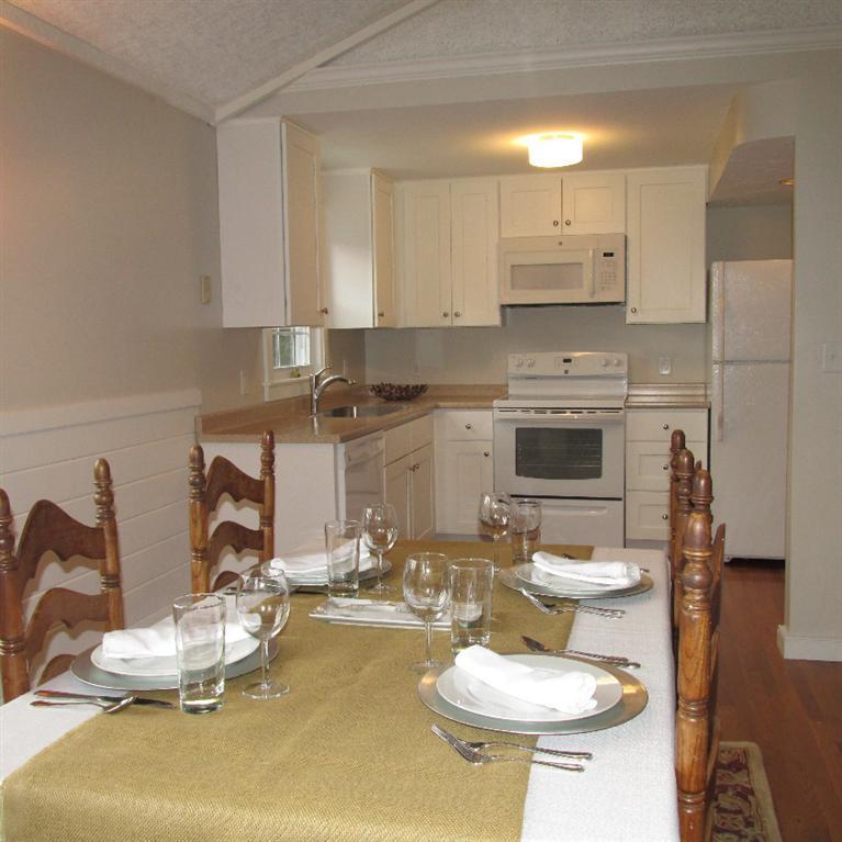 1 Mashnee Road Bourne, MA 02532 - Photo 6 of 29 a kitchen with a sink a stove and chairs with wooden floor