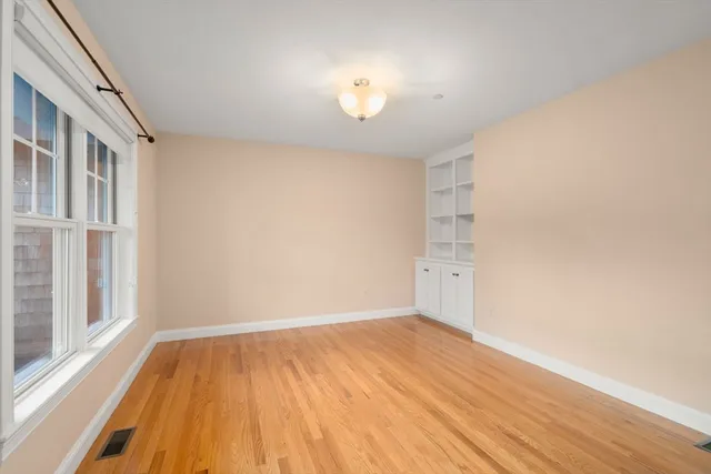 a view of a room with wooden floor and a window