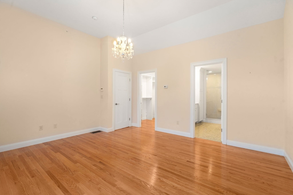 9 River Rock Way, Unit 9 Wayland, MA 01778 - Photo 16 of 39 a view of empty room with wooden floor and chandelier