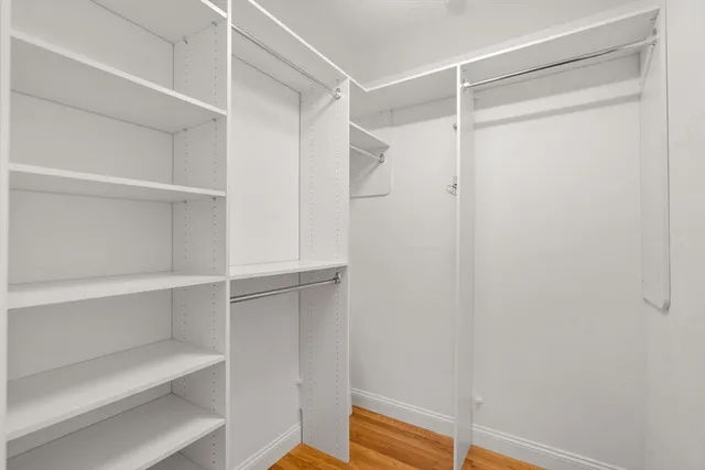 a view of walk in closet with empty racks