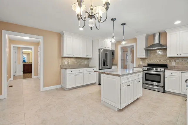 a kitchen with kitchen island granite countertop a stove oven and a refrigerator