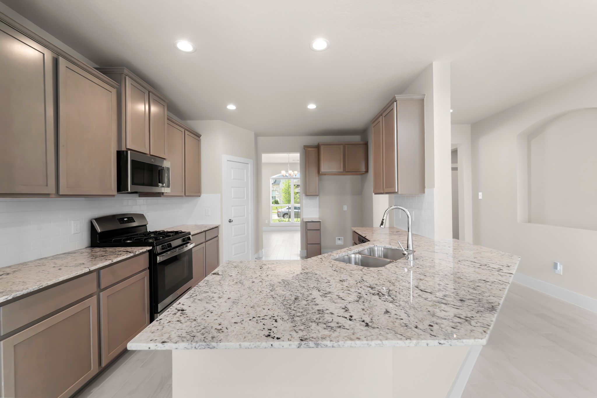 18423 Windy Knl Way Houston, TX 77084 - Photo 10 of 39 a kitchen with granite countertop stainless steel appliances a sink a stove top oven a counter space and cabinets