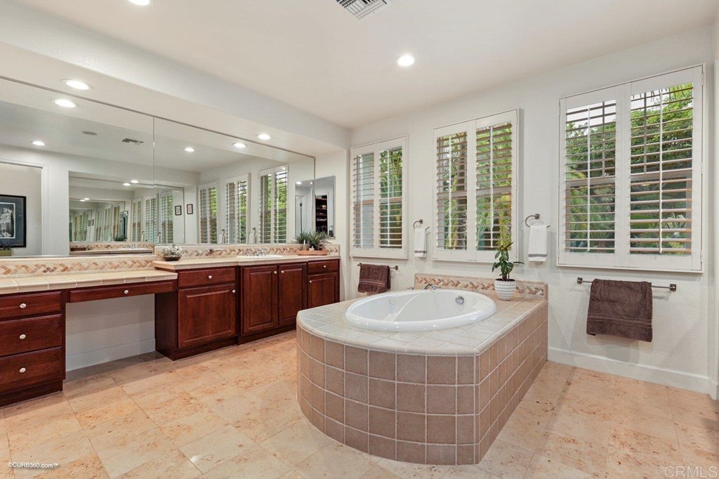 7338 Corte TOMILLO Carlsbad, CA 92009 - Photo 27 of 36 a large bathroom with a tub sink shower and mirror