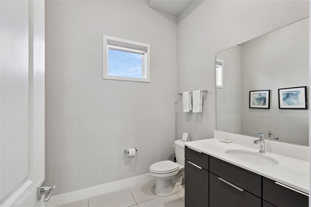 7770 Sandy Ridge Drive, Unit 223 Reunion, FL 34747 - Photo 12 of 51 a bathroom with a toilet a sink a mirror and vanity