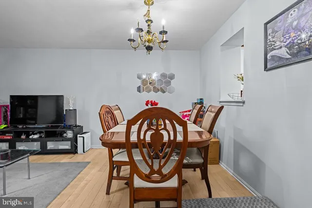 a dining room with furniture potted plants and wooden floor