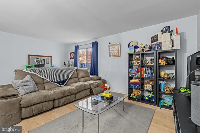 a living room with furniture cabinets and wooden floor
