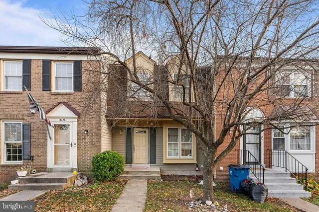 a front view of a house with a tree