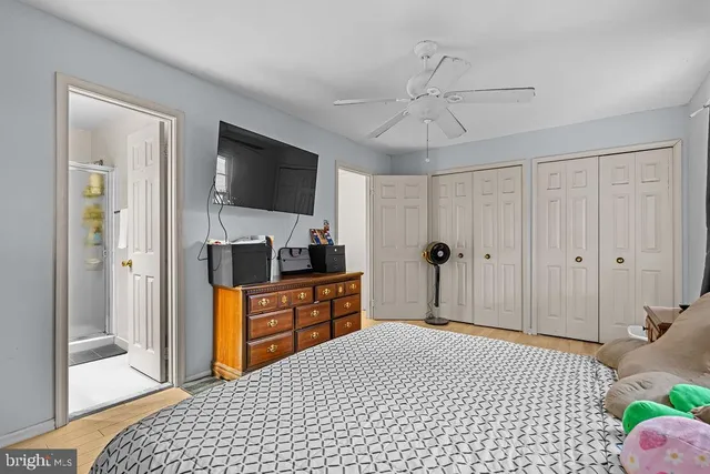 a bedroom with a bed and a flat tv screen on dresser