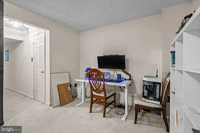 a view of a workspace with furniture and a window