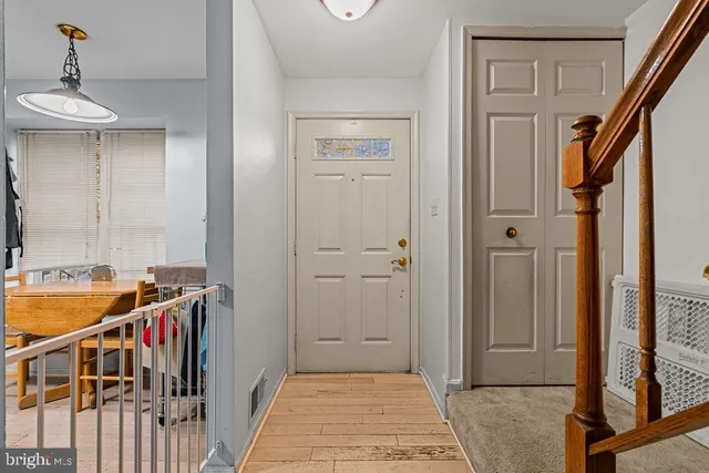 a view of a hallway with a dining table and chairs