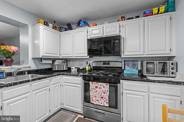 a kitchen with stainless steel appliances granite countertop a stove a microwave and cabinets