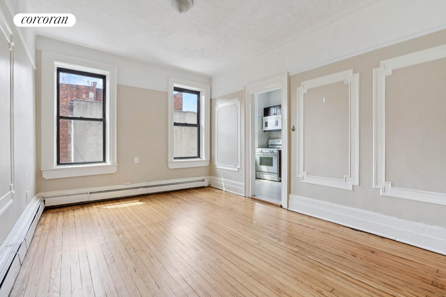 248 Rochester Avenue Brooklyn, NY 11213 - Photo 3 of 21 an empty room with wooden floor and windows