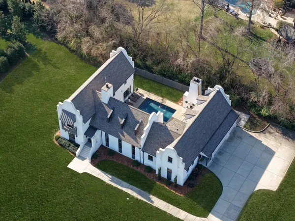 a dining room with wooden floor a chandelier a glass table and chairs