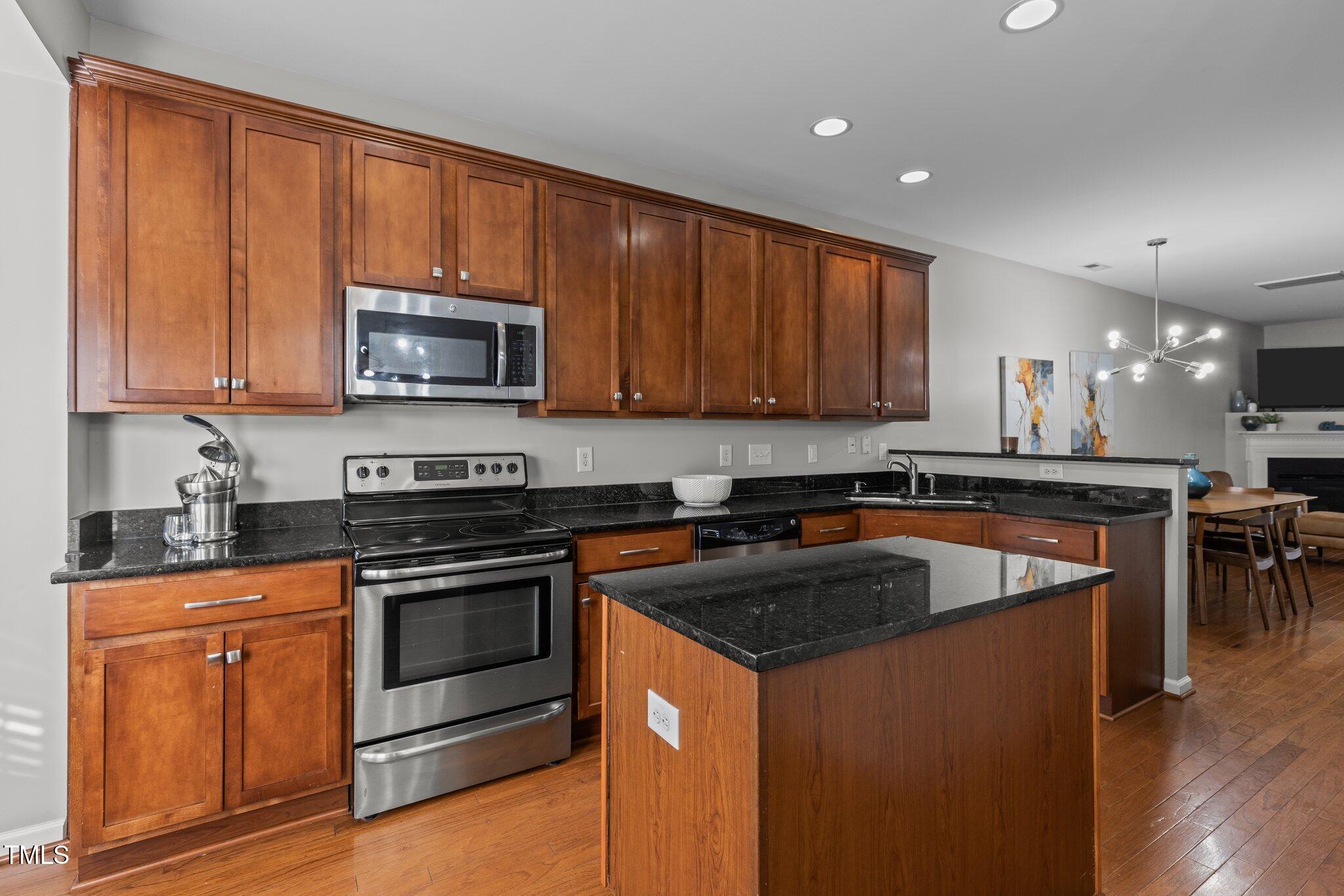 1667 Snow Mass Way Durham, NC 27713 - Photo 6 of 33 a kitchen with stainless steel appliances granite countertop a stove a sink and a microwave
