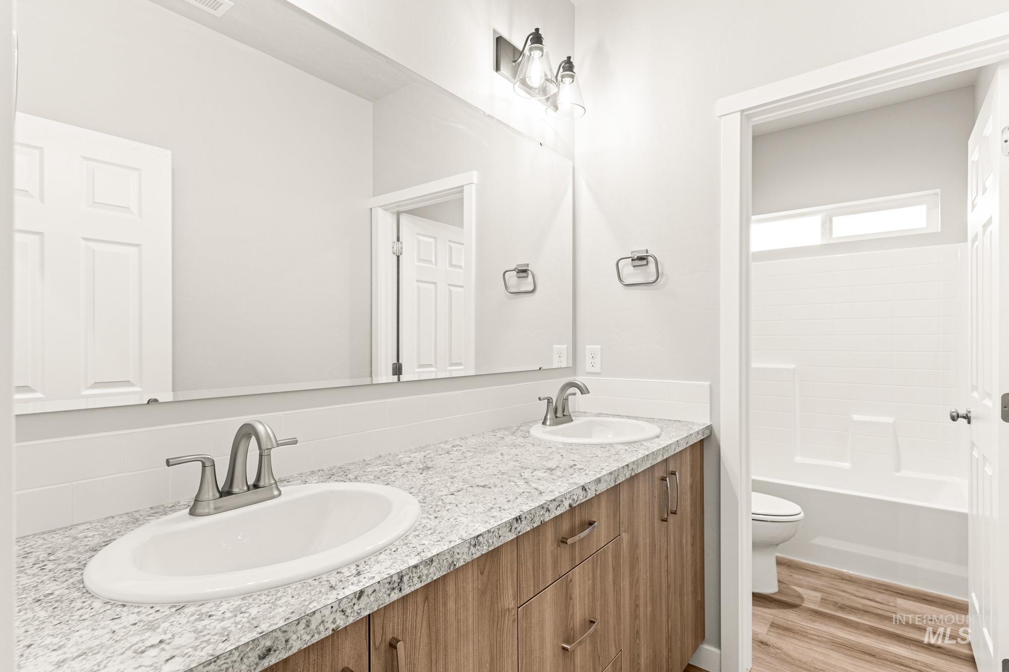448 Merlin Court Middleton, ID 83644 - Photo 29 of 29 Dual vanity with brushed nickel fixtures, wood-finish cabinetry, and light-toned countertops