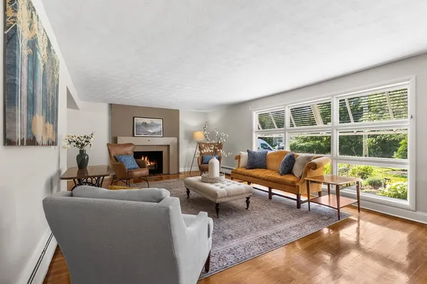 a living room with furniture a fireplace and a large window