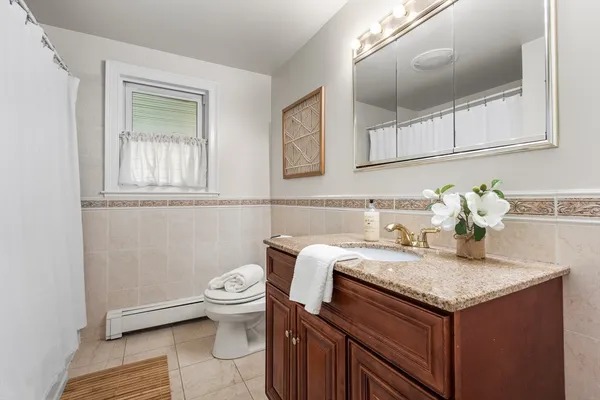 a bathroom with a granite countertop toilet sink and mirror