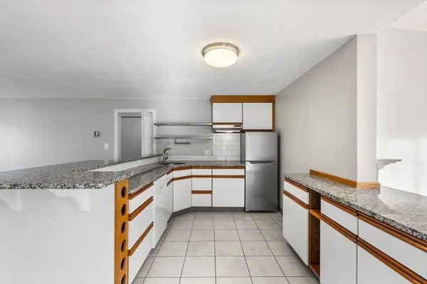 a large kitchen with granite countertop a sink and a stove top oven