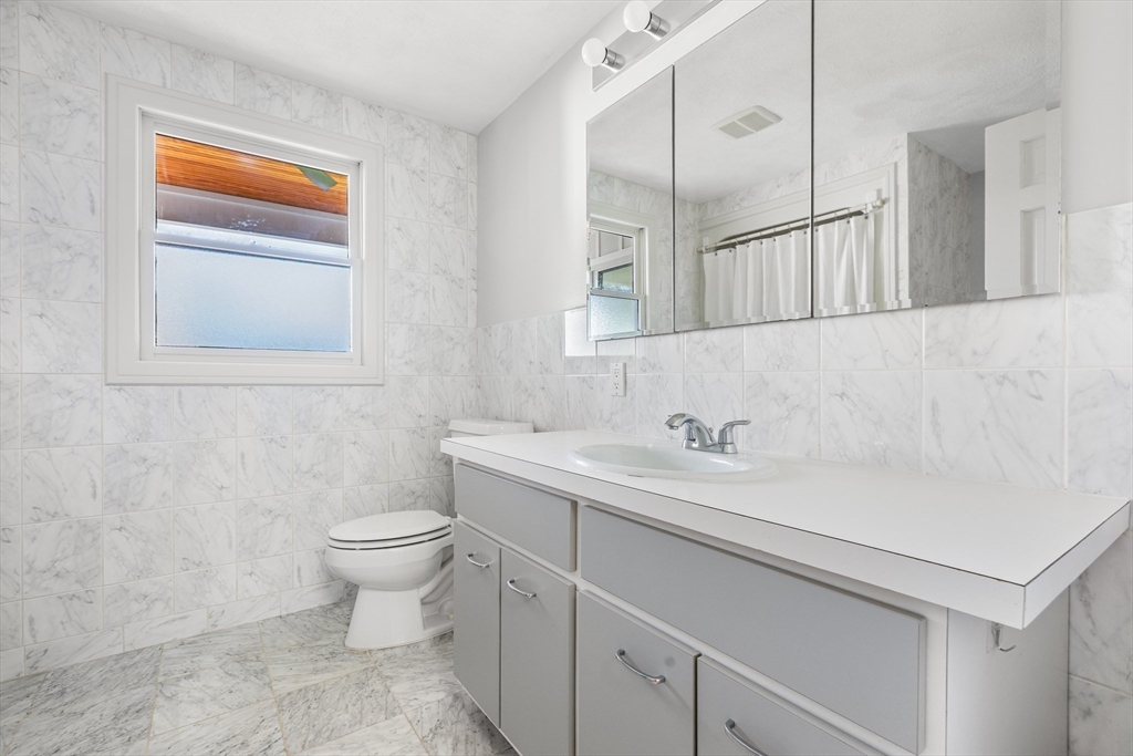 409 Haverhill Street Reading, MA 01867 - Photo 39 of 42 a bathroom with a sink a toilet and mirror