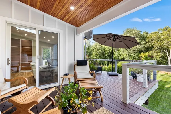 a view of a patio with wooden chairs and floor