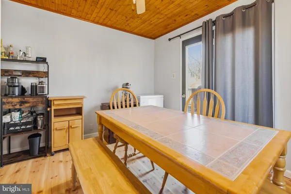 a living room with stainless steel appliances furniture a rug and a kitchen view
